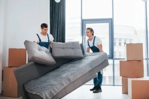 carrying-heavy-sofa-two-young-movers-blue-uniform-working-indoors-room_146671-52053.webp