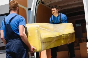 selective-focus-movers-unloading-sofa-stretch-wrap-truck-outdoors_824701-2855-1.webp
