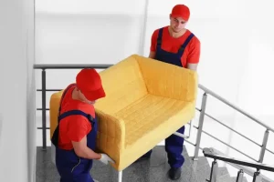 two-male-workers-with-yellow-couch-staircases_392895-223222.webp